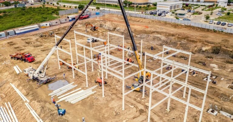 Công trường dựng khung thép nhà xưởng với cần cẩu và máy móc thi công