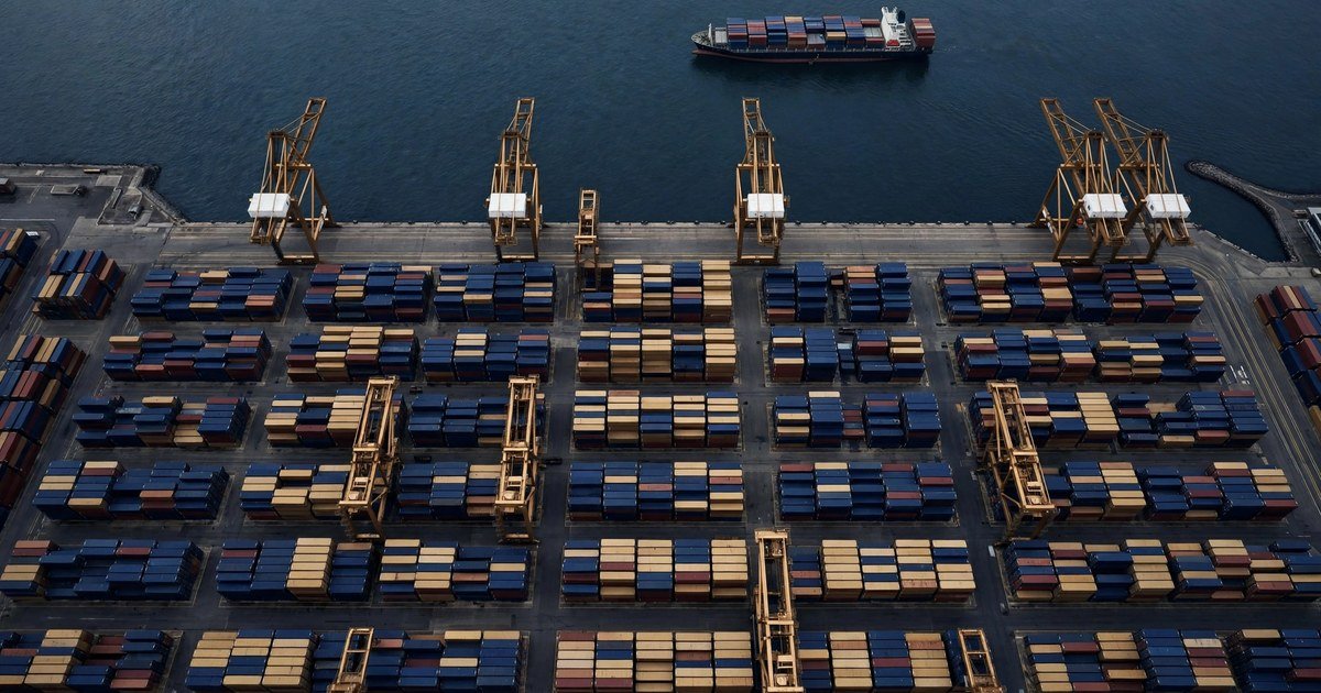 Cảng container nhìn từ trên cao với các cần cẩu và tàu hàng neo đậu, tông navy và vàng đồng