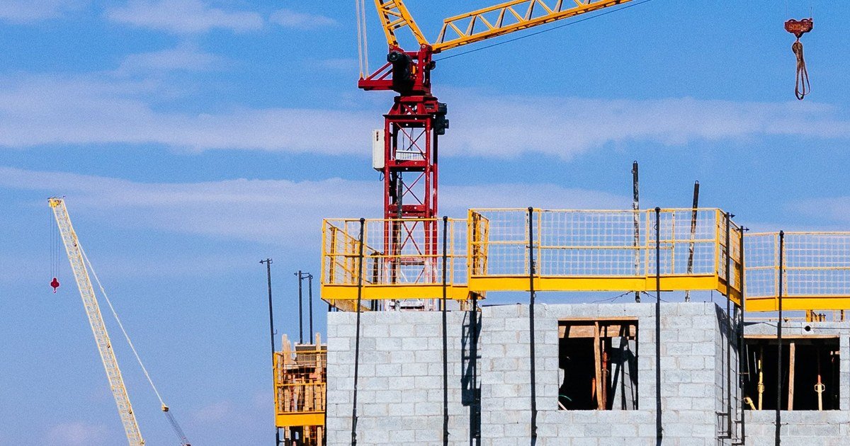 Công trường xây dựng với cần cẩu tháp dưới bầu trời xanh
