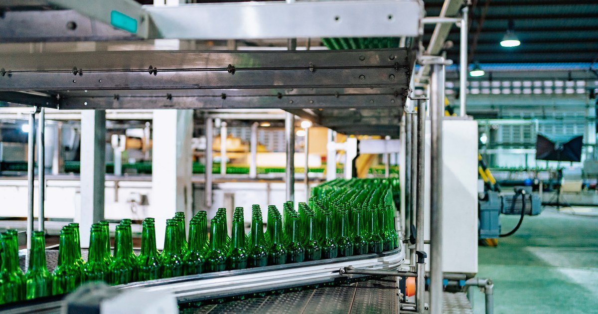 OEM Contracts with Chinese Factories: 10 IP Clauses 1 Chai thủy tinh xanh xếp hàng trên băng chuyền trong nhà máy
