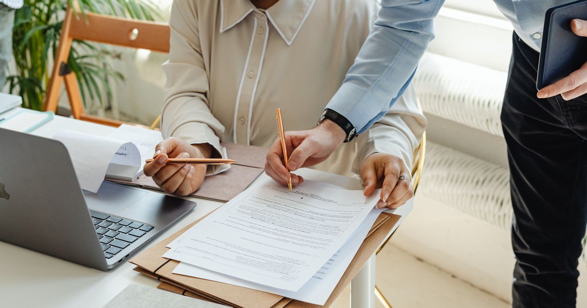 Case Study: Bilingual Contract Conflict and Lessons 1 Hai bên cùng rà soát và ký tài liệu trên bàn làm việc, minh họa bài học từ mâu thuẫn hợp đồng song ngữ