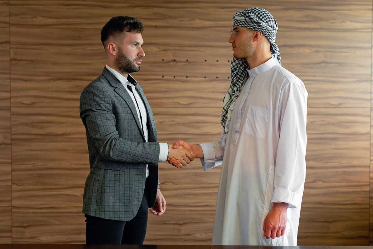 Two businesspeople shaking hands, cross-cultural partnership