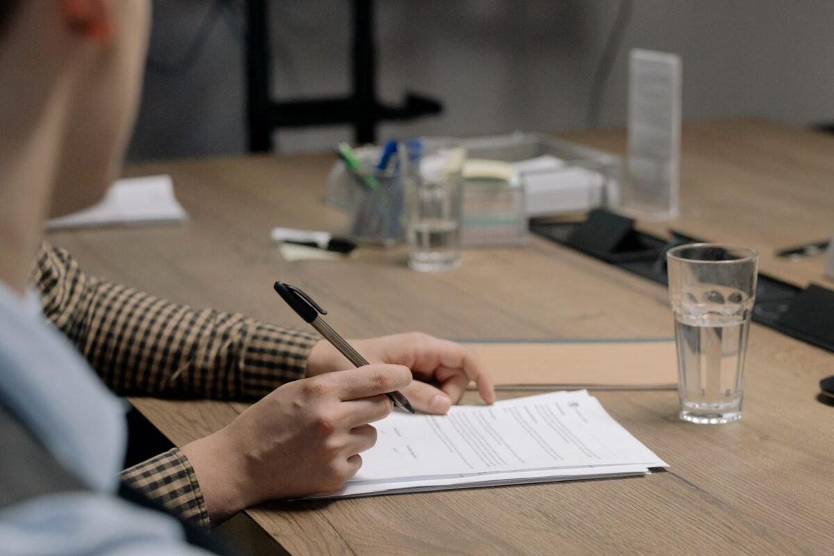 Which Investment Projects Require an EIA Report? 2026 Classification List 4 Person signing documents on a wooden desk
