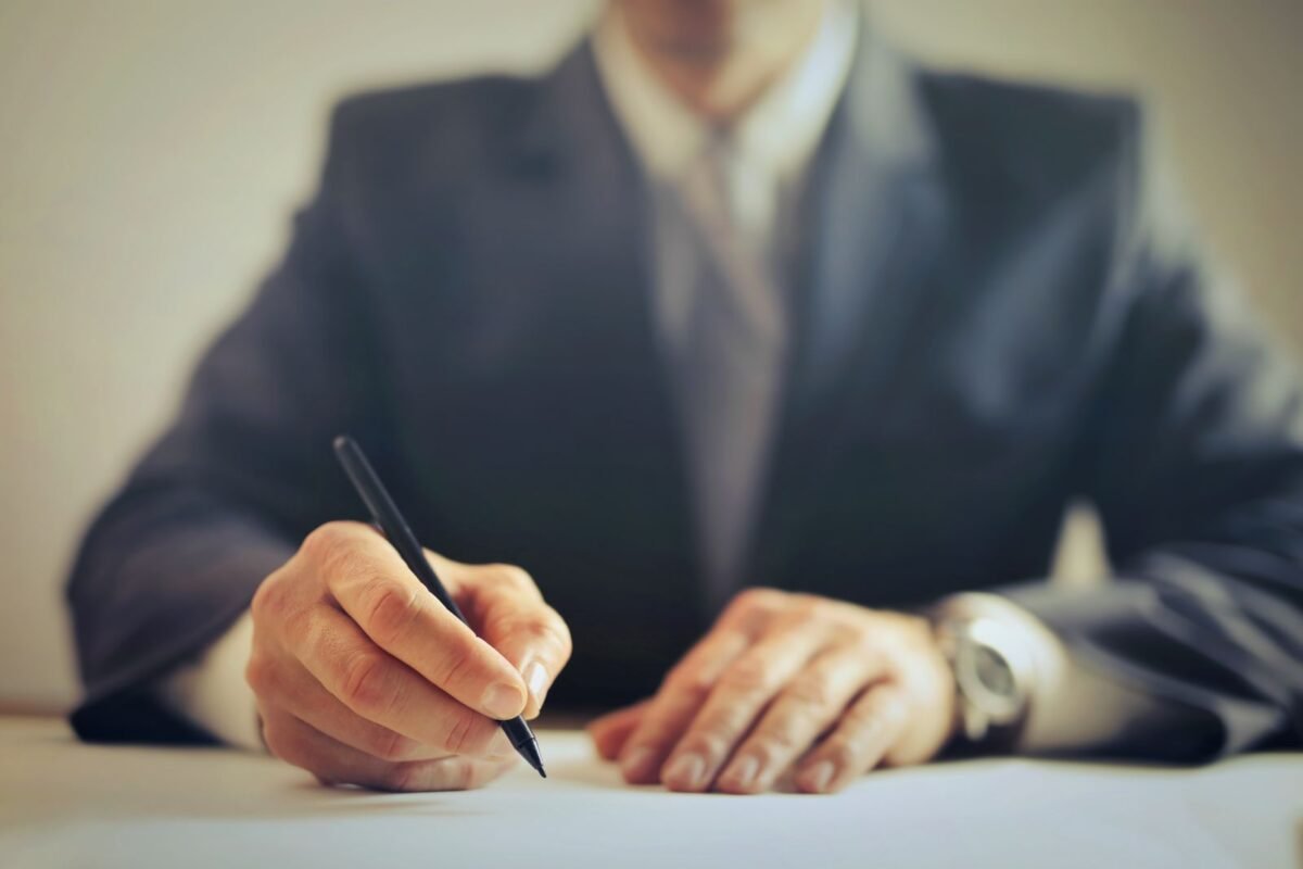 Businessperson signing a contract at an office desk