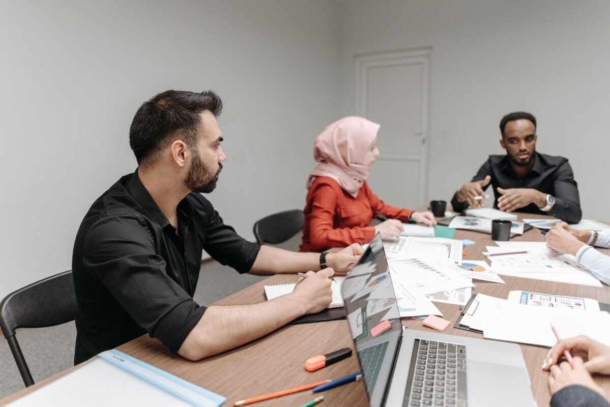 Business team meeting around a table with a laptop