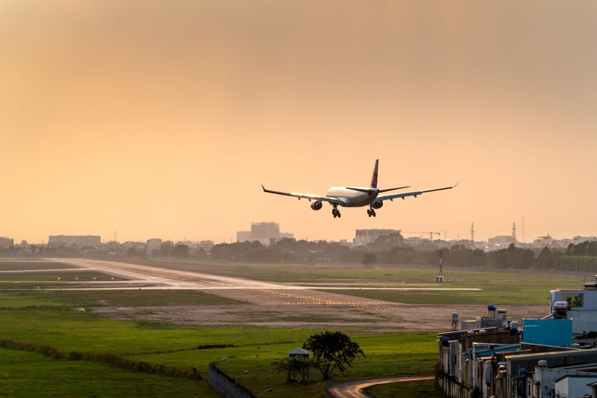 Máy bay cất cánh trên đường băng lúc hoàng hôn — minh họa dẫn độ tội phạm kinh tế bỏ trốn ra nước ngoài, không mặt người