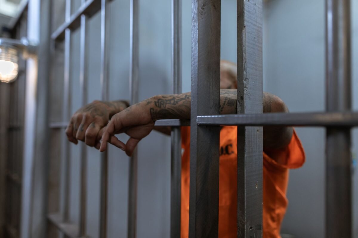 Compensation for wrongful prosecution in Vietnam: who qualifies? 1 Inmate's arm through prison cell bars — state compensation for wrongful conviction, no face visible