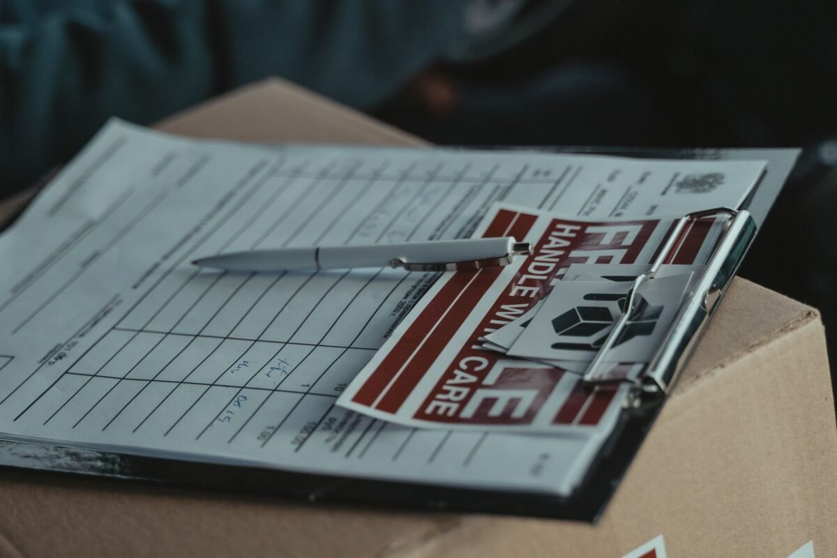 Import customs dossier documents — clipboard with delivery documents and pen, no faces