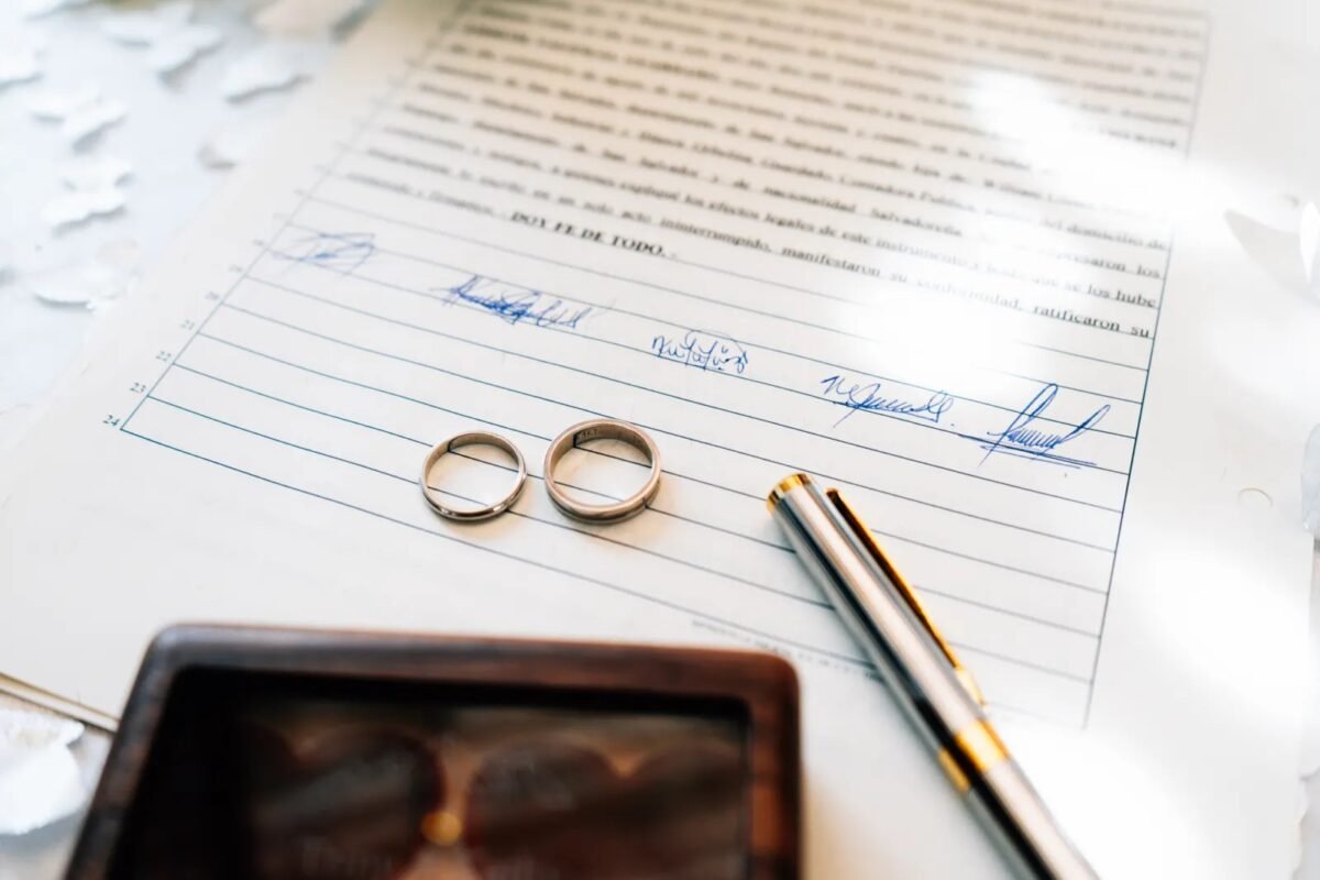 Wedding rings on a signed marriage certificate — marriage-based temporary residence card