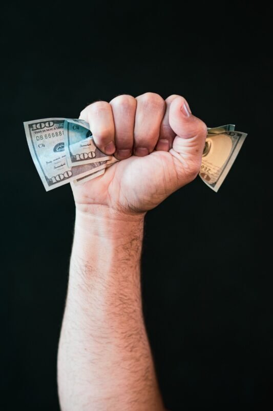 Hand holding US dollar bills — illustrating interest income from intercompany loans subject to CIT, no face visible