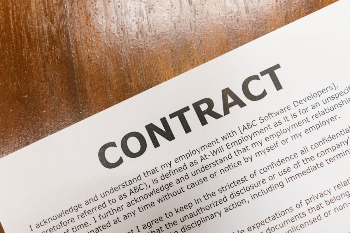 Bilingual Vietnamese–English Labor Contract: Mandatory Clauses 1 Contract and pen on a wooden desk — illustration for the article on the bilingual Vietnamese-English labor contract template