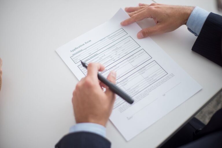 Employment contract with a foreign expert — hands reviewing a job application form