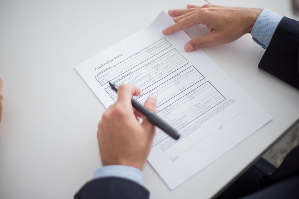 Employment contract with a foreign expert — hands reviewing a job application form