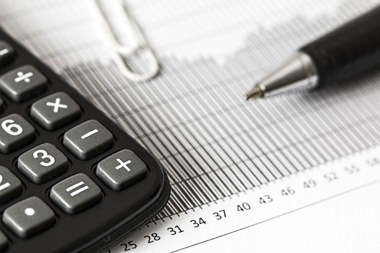 Close-up of a calculator and pen on a bar graph, finance and accounting