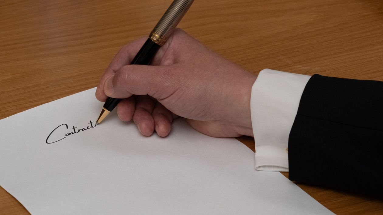 Công ty có được ủy quyền cho luật sư làm việc với cơ quan nhà nước? 1 Tay ký chữ Contract trên văn bản ủy quyền