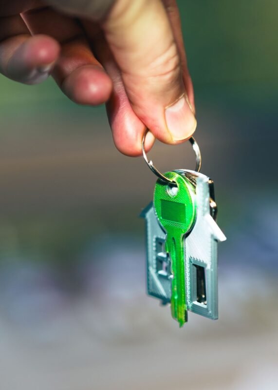 Hand holding house-shaped keys — leasing or borrowing assets
