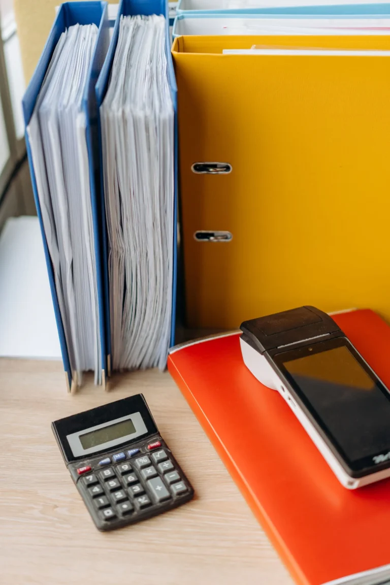 Calculator, file binders and documents on a desk — illustration for an article on social insurance for Vietnamese–Chinese workers