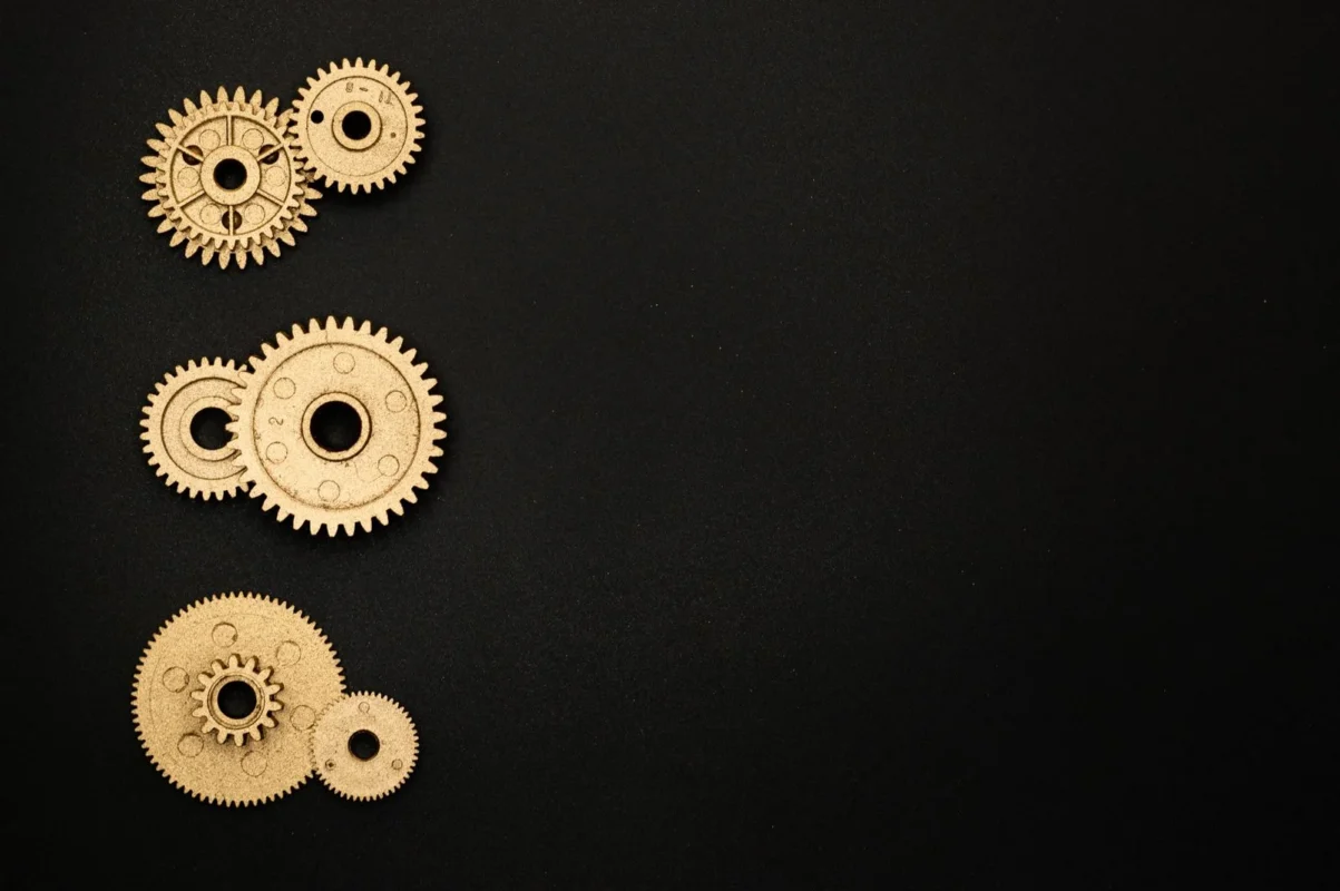 Golden metal gears on a black background — illustration for an article on restructuring Chinese-invested enterprises