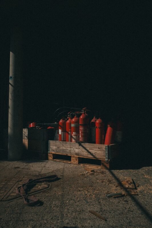 Red fire extinguisher against a gray wall — illustration for the article on fire safety and environmental inspections for Chinese factories in Vietnam