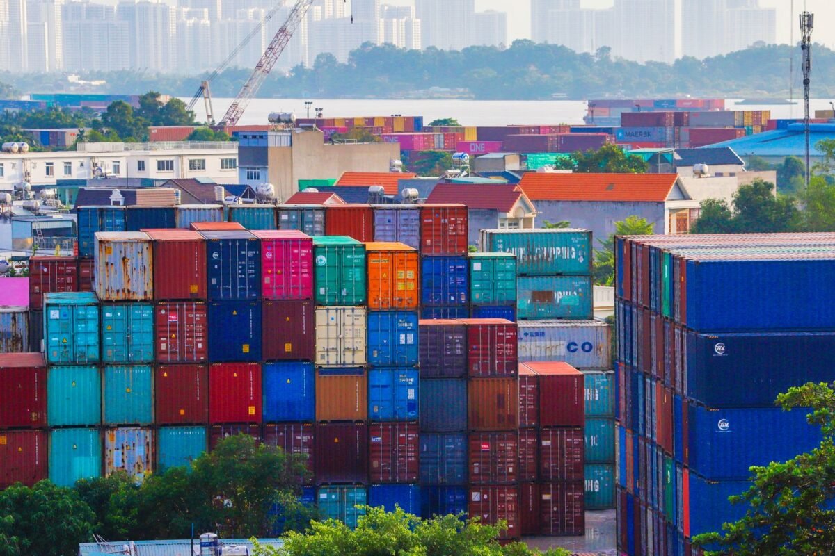 Vietnamese Exports to China Under Anti-Dumping Investigation: How to Respond? 1 Stacked shipping containers at a seaport — illustration for the article on responding to anti-dumping investigations against Vietnamese exports to China