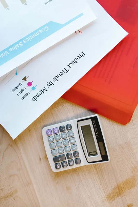 Calculator on a desk with business documents and charts