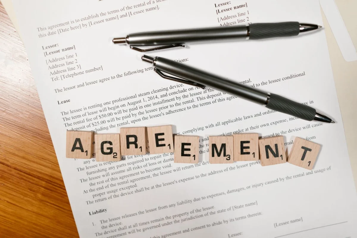 Tài liệu với chữ AGREEMENT và hai cây bút