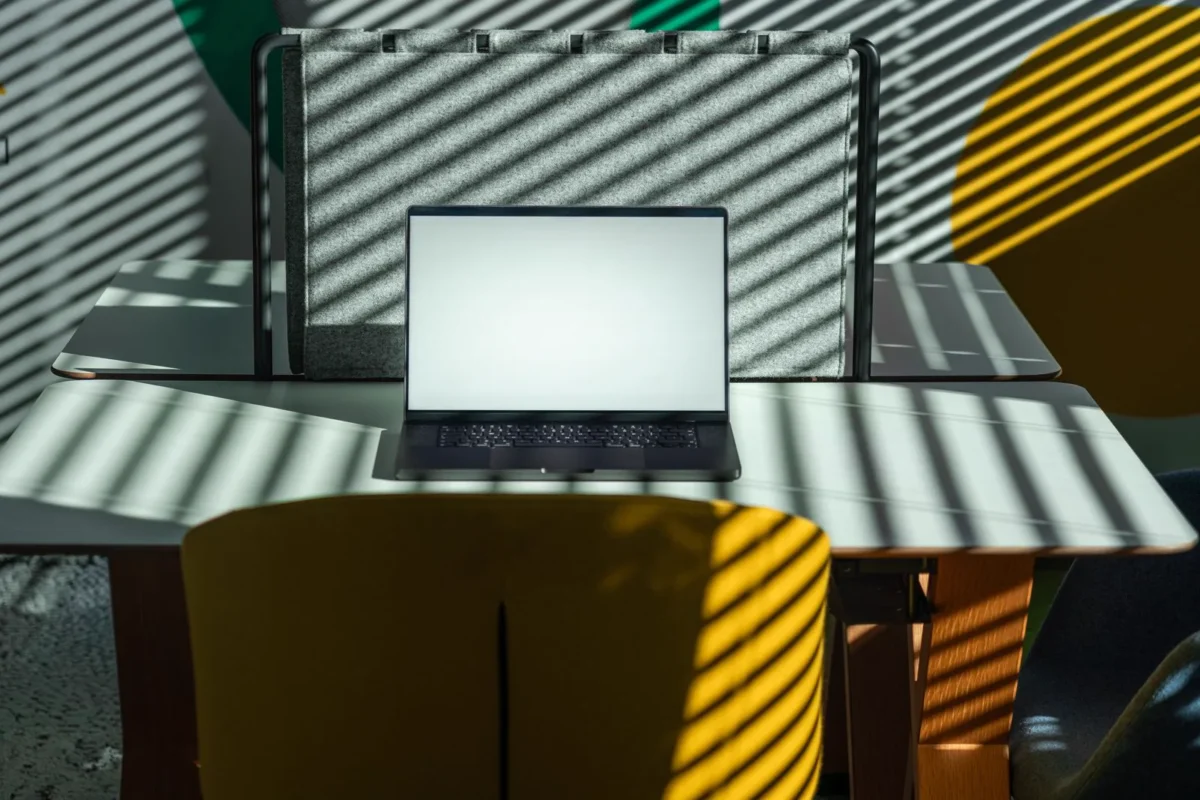 Empty modern office desk with laptop; no people