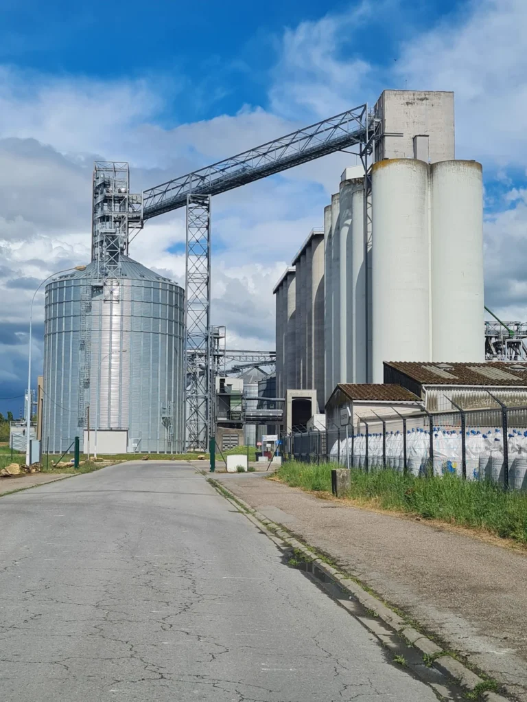 Industrial silos and factory buildings under blue sky; no people