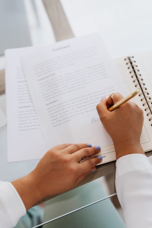 Hands signing contract documents, illustrating voluntary remediation by a corporate entity for a reduced sentence
