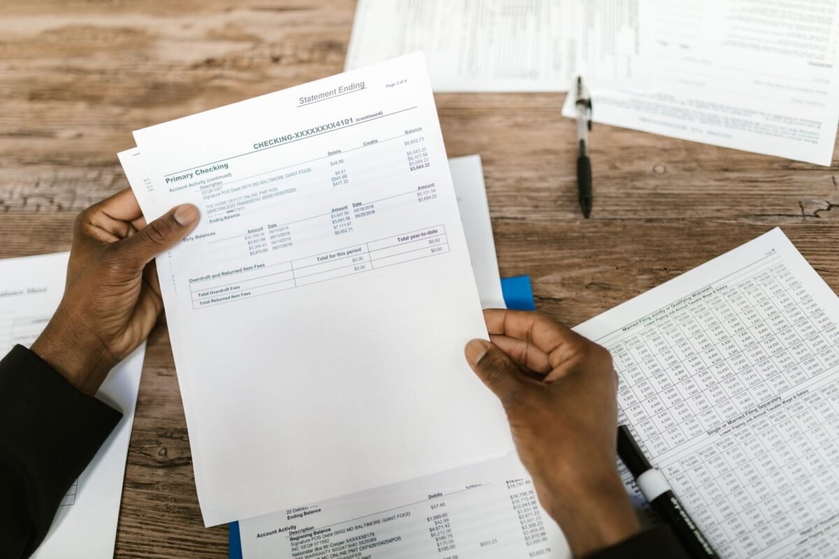 Hands holding a bank statement, illustrating how a criminal investigation affects corporate bank accounts and contracts