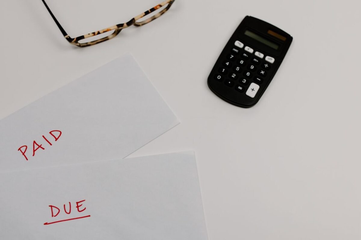 Tax invoices, documents and a calculator on a desk