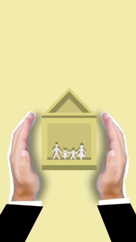 Hands holding a paper cutout of a house with a family — illustrating insurance company acquisition, no faces