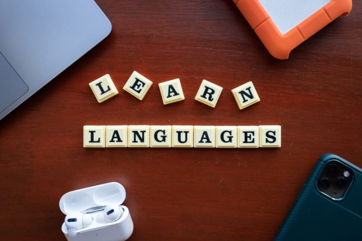 Acquiring a Language or Training Centre in Vietnam: Legal Conditions 1 Wooden letter tiles spelling LEARN LANGUAGES on a desk — illustrating language training centre acquisition, no people