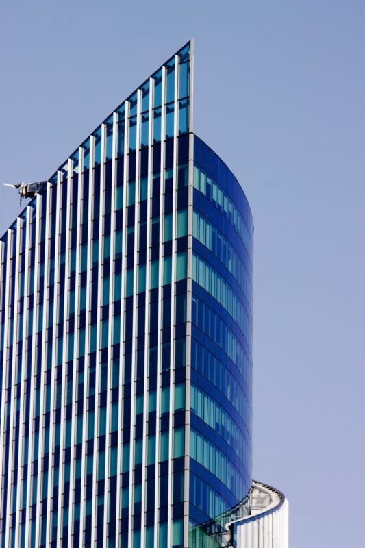 Modern glass skyscraper facade against clear blue sky