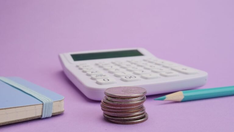 Stack of coins and calculator for financial calculation