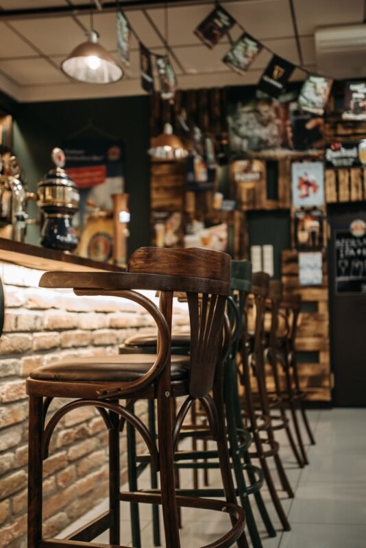 Empty pub interior with bar stools — illustrating conditions and dossier for the Security and Order Certificate for bars and pubs