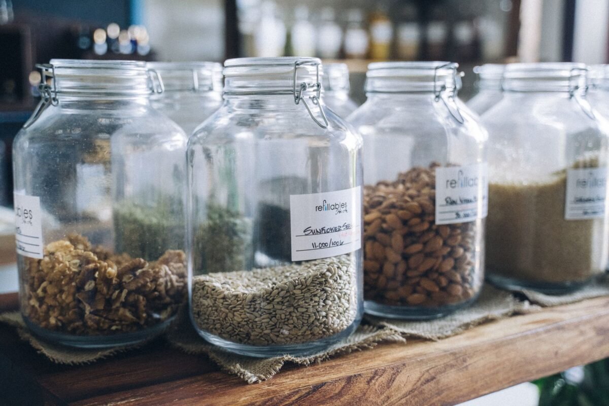 Glass storage jars with food labels on a wooden shelf