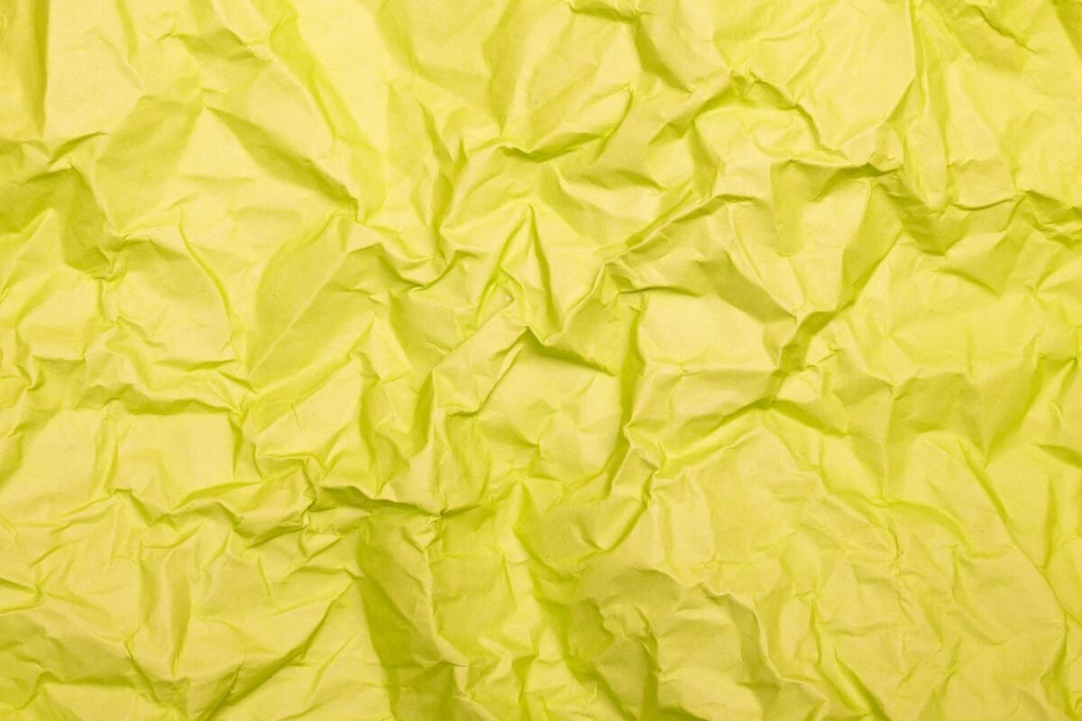 揉皱的黄色纸张特写——因连续五年未使用而撤销商标示意，无人物
