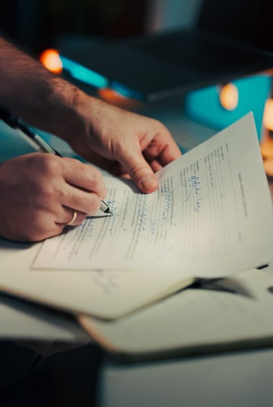 Businessman signing documents in an office — illustrating unrecorded trademark licences in Vietnam, no face visible