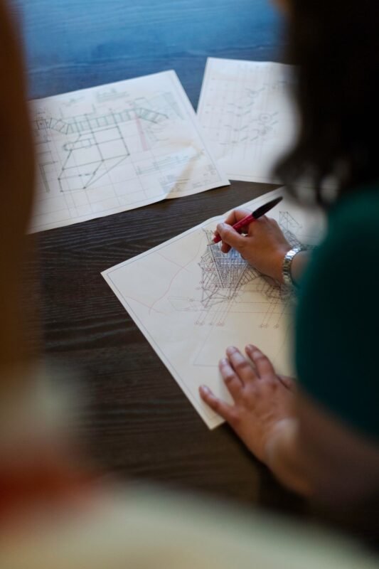 Person sketching engineering designs — illustrating assigning patent ownership in Vietnam, no face visible