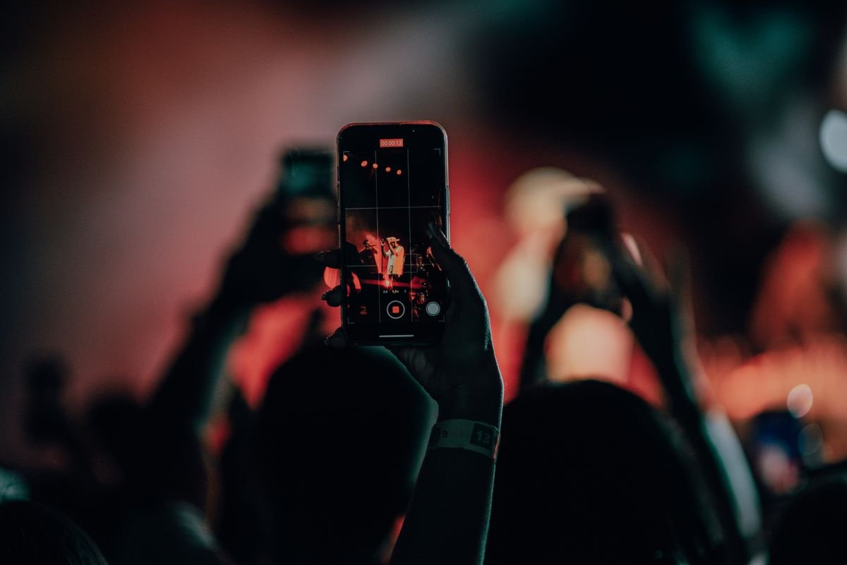 Filming with a smartphone at an event illustrating an article on copyright infringement on YouTube and TikTok in Vietnam