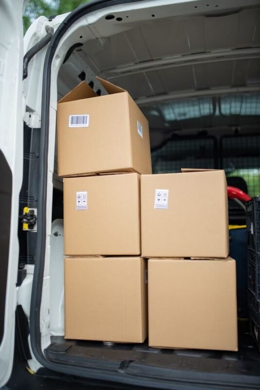 Removing IP-Infringing Listings from E-Commerce Platforms: Complaint Steps 1 Delivery van loaded with cardboard parcels — illustrating an article on removing IP-infringing goods from e-commerce platforms