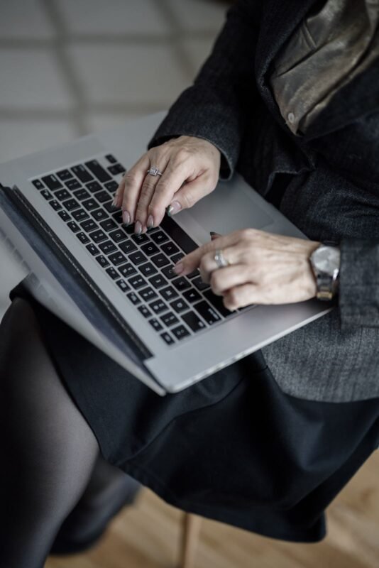 Office staff typing on a laptop in a modern office — illustrating data processing and compliance activities at an FDI enterprise