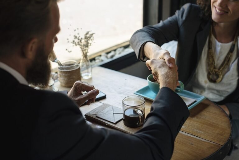 Two business partners shaking hands over an agreement