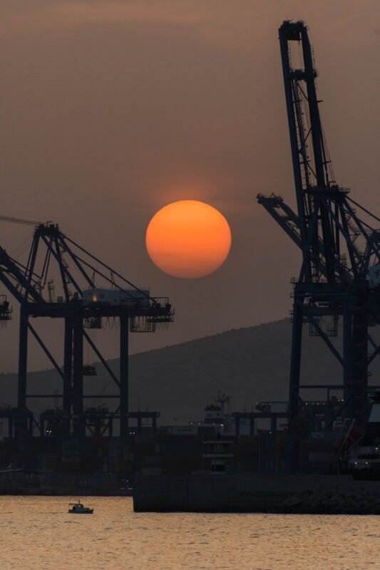Appealing customs administrative penalty decisions — dramatic sunset over industrial port cranes, no people