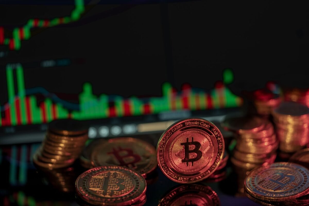 Bitcoin coins in front of a financial market chart, illustrating digital investment trends