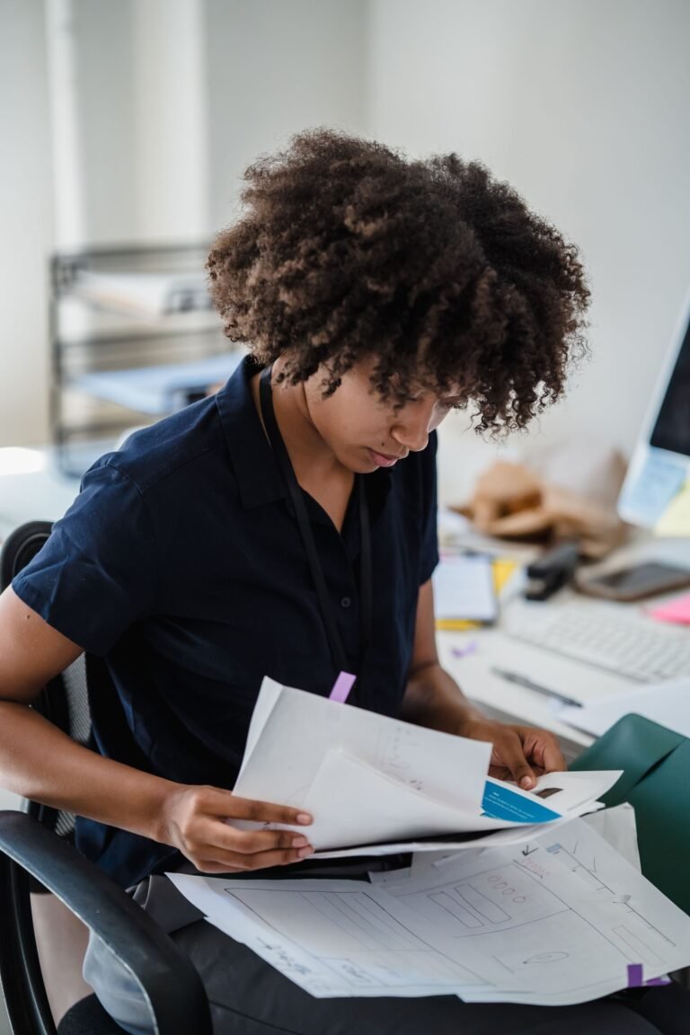 Woman in an Office Looking Through Papers on her Lap