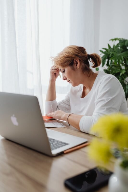 Losing passport with residence card abroad: how to handle? 1 Worried Woman Sitting in an Office in front of her Laptop