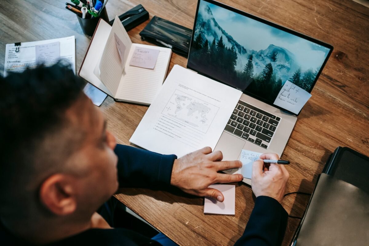 Photo Of Man Writing On A Piece Of Paper