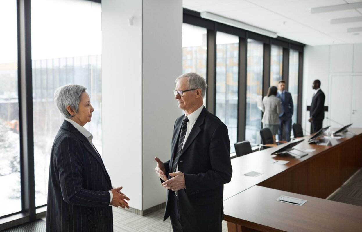Man in Black Suit Facing a Woman in a Black Blazer
